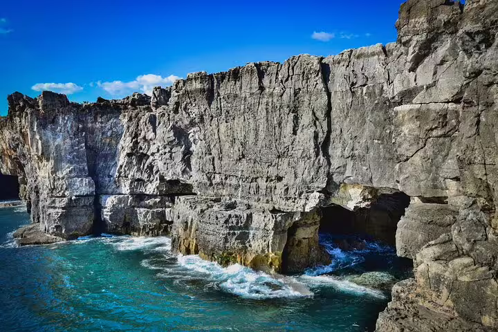 Dramatic rocky cliffs and azure waters of the Portuguese coastline, part of Sintra Private Full-Day Tour highlights.