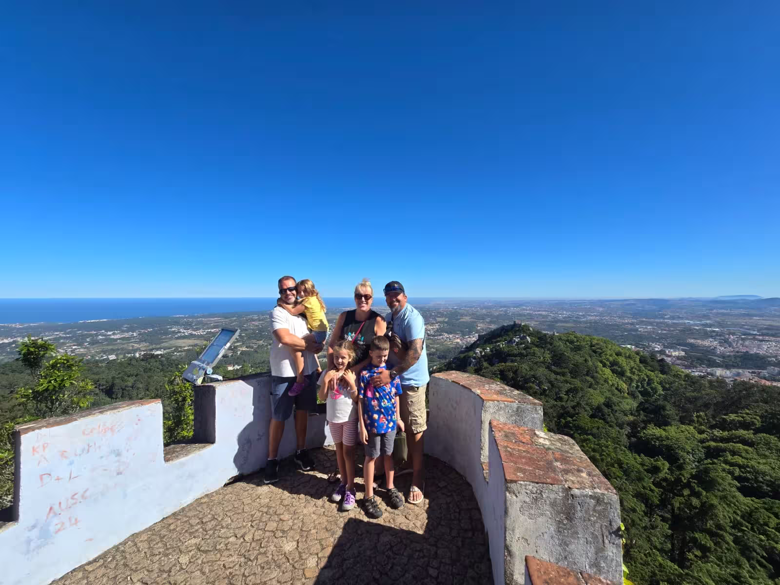 Family at scenic viewpoint in Sintra with expansive ocean views, perfect for the Sintra to Cascais day trip.