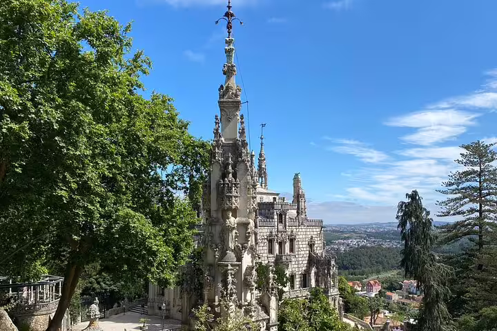 Majestic hilltop palace surrounded by trees with panoramic views on Sintra-Cascais Jeep Tour.