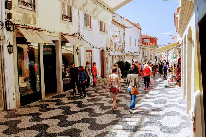 Tourists explore the charming streets of Cascais Village on a sunny day, highlighting the beauty of Sintra World Heritage sites.