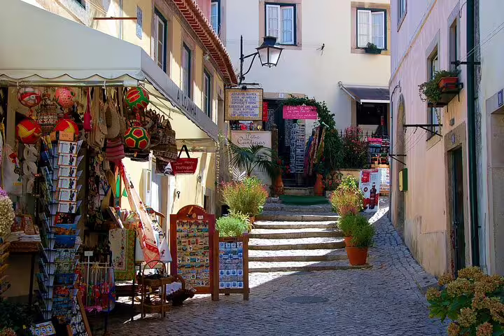 Charming Sintra street with colorful shops and cobblestone path on guided Lisbon tour.