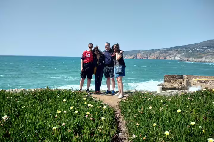 Tourists enjoy stunning ocean views and lush greenery on the Sintra & The Amazing Dream Villages Tour in Portugal.