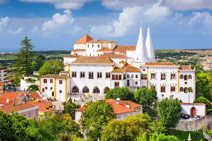 Aerial view of the stunning National Palace of Sintra surrounded by lush greenery, featured in the Sintra, Cascais & Estoril tour.