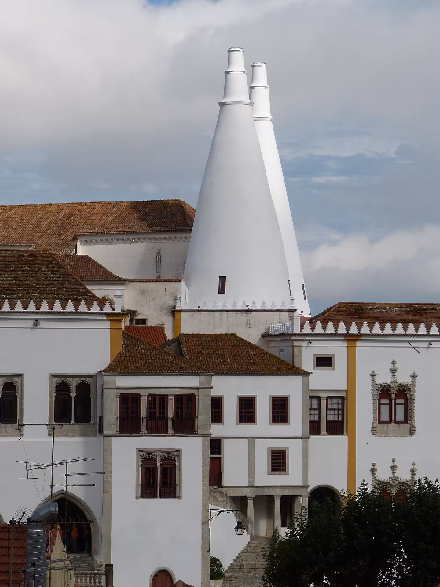 Iconic white conical chimneys of Sintra National Palace up close on a guided e-bike palace tour in Portugal