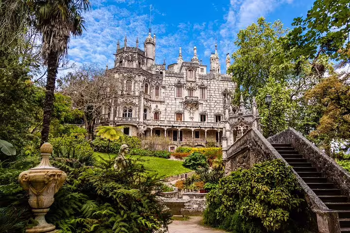 Ornate palace surrounded by lush gardens, showcasing Sintra's architectural beauty on a private panoramic tour of Cabo da Roca, Cascais, and Estoril.