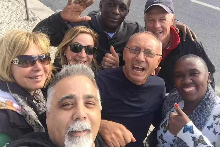 A joyful group of tourists enjoying the Sintra, Pena Palace, and Cascais full-day tour from Lisbon.