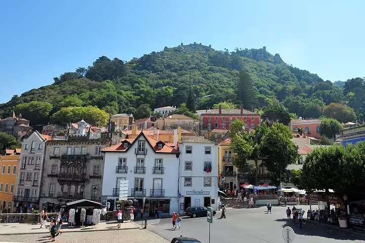 Bustling square with traditional architecture against lush Sintra hills on the Lisbon day tour to Cascais.