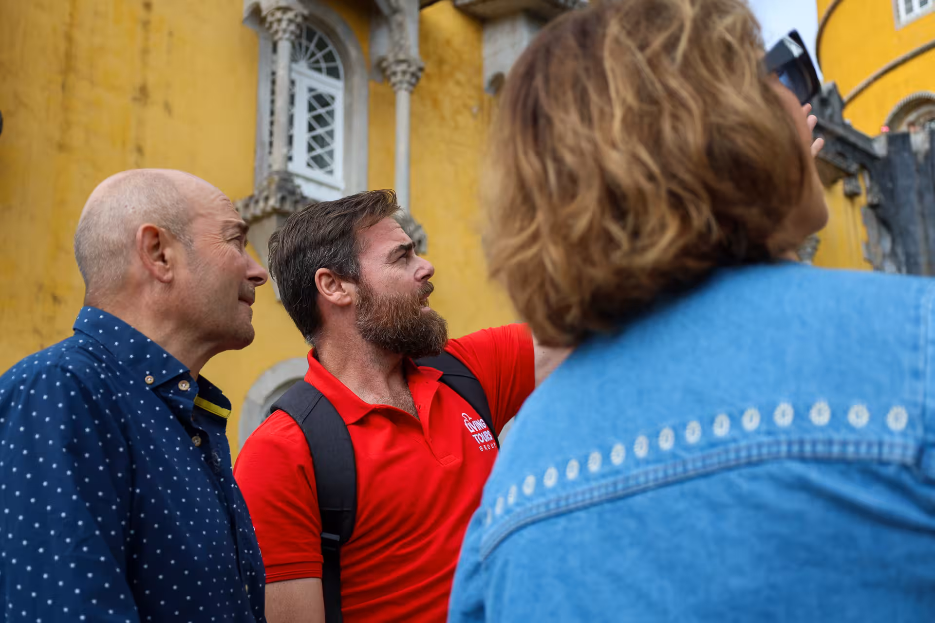 Tour group admiring Pena Palace's architecture on a guided tour from Lisbon to Sintra.