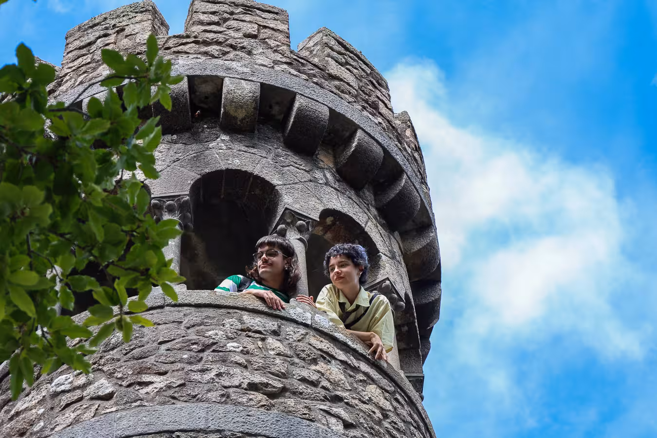 Visitors enjoy the view from a stone turret at Regaleira, Sintra, highlighting the historical allure of the tour.