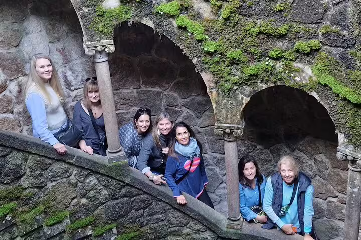 Tourists explore the mystical Quinta da Regaleira initiation well on a private Sintra monuments tour from Lisbon.