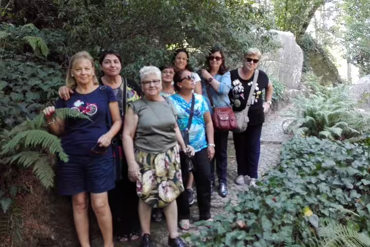 Group of women enjoying a scenic forest walk during the Sintra, Roca, and Cascais full-day private tour with Pena tickets.