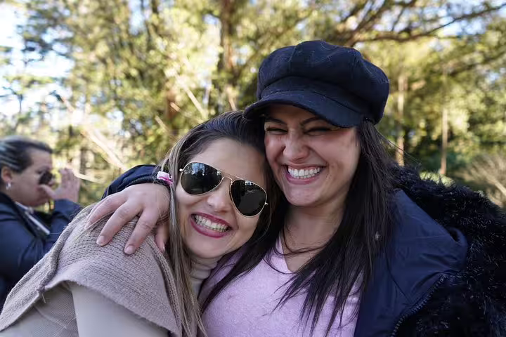 Two smiling women enjoying a sunny day on the Sintra, Roca, and Cascais full-day private tour, highlighting joy and adventure.