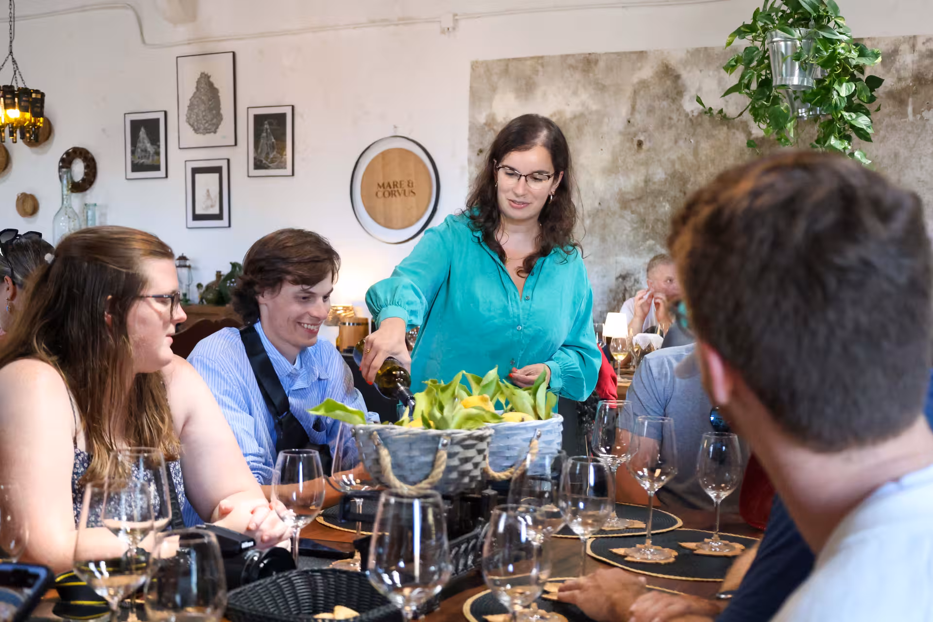 Group enjoying an intimate wine tasting session in Sintra with a guide pouring wine at a cozy setting.