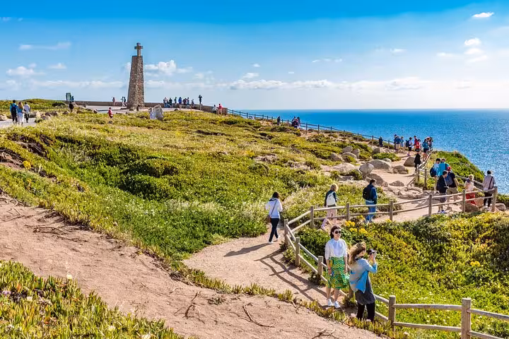 Visitors enjoying scenic views at Cabo da Roca during the Sintra and Wine Full Day Tour from Lisbon.