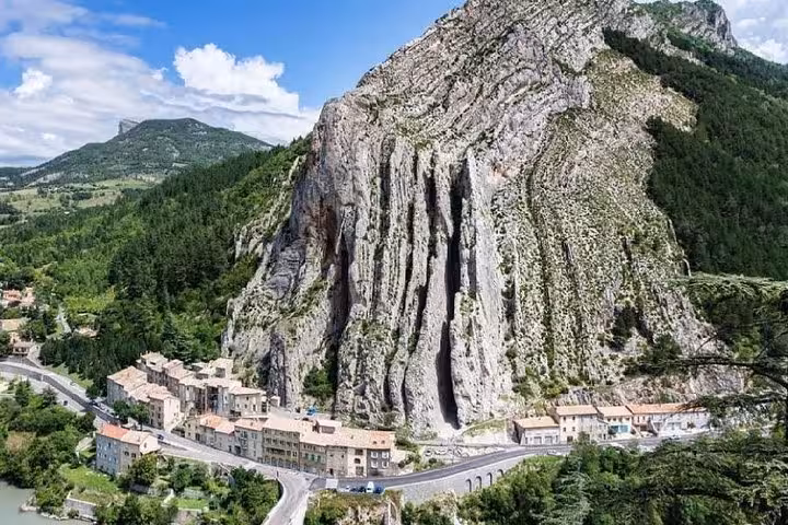 Dramatic limestone rock face towering over the historic village of Sisteron along a winding road in Provence, France