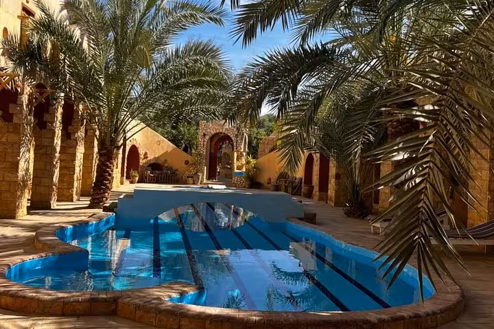 Desert lodge pool framed by palms in Siwa Oasis, Egypt, on a 3-day Sahara safari with salt lakes
