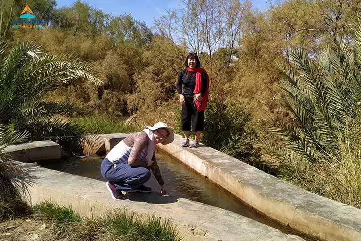 Travelers by a desert spring in Siwa Oasis, Egypt, on 15-day Pyramids Luxor Aswan Oasis tour