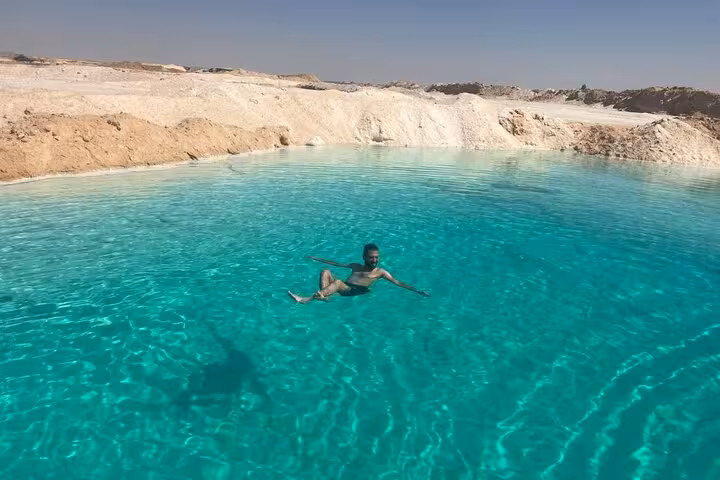 Floating in Siwa Oasis turquoise salt lake on a private 3-day Sahara safari with springs and salt lakes