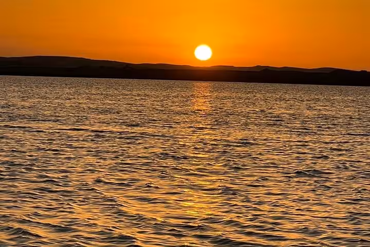 Golden sunset over Siwa Oasis salt lake with Sahara dunes, scenic stop on a 3-day private desert safari