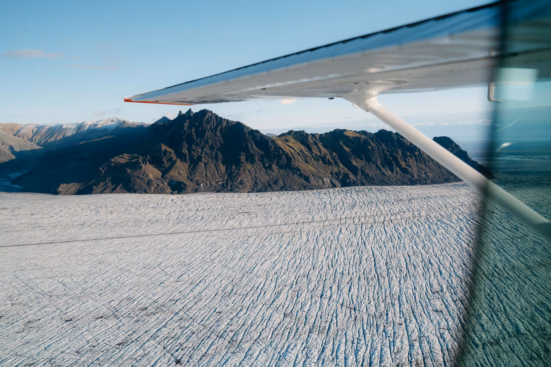 Aerial view of Skaftafell glacier and rugged mountains in Iceland from a small plane window