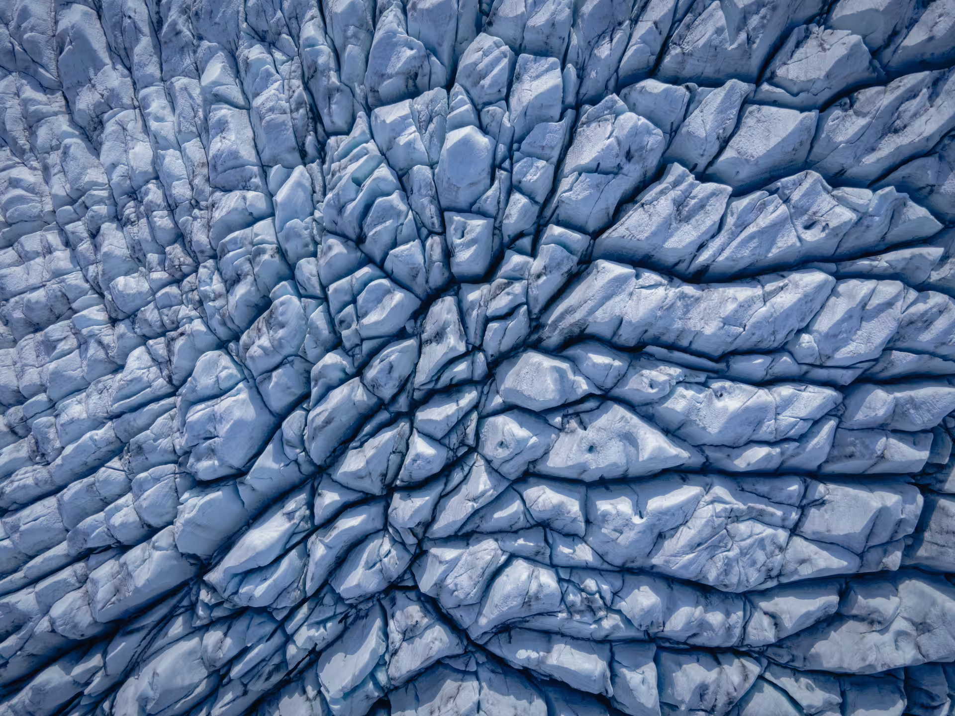 Aerial view of glacier ice formations with radiating crevasse patterns over Skaftafell, Iceland
