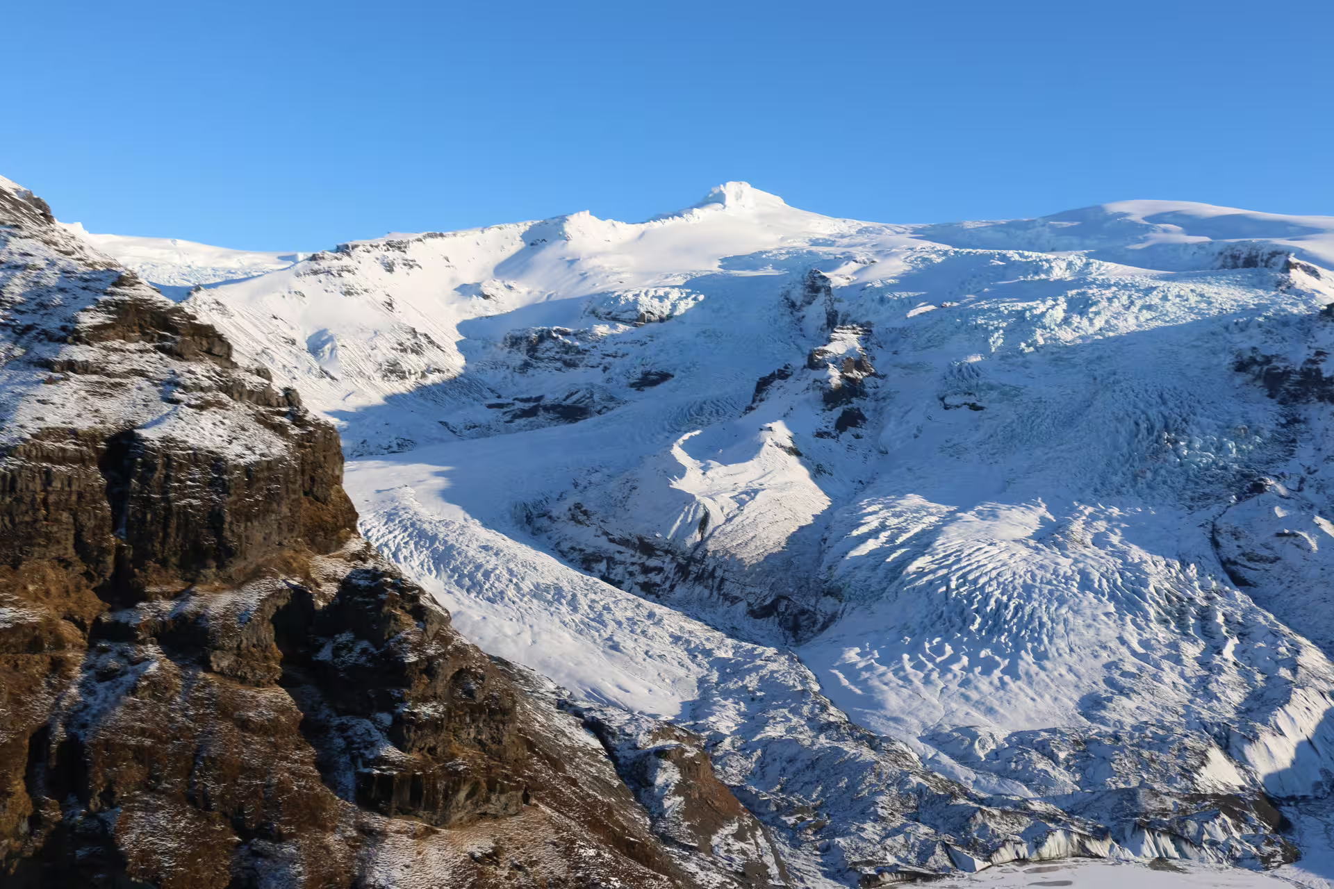 Aerial view of snow-covered glaciers and rocky peaks in South Iceland near Skaftafell