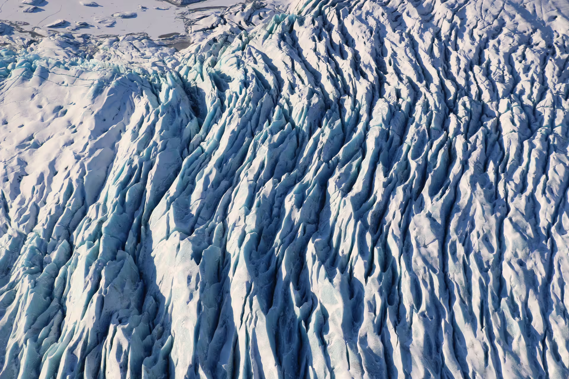 Aerial view of heavily crevassed glacier ice with blue hues and jagged ridges at Skaftafell