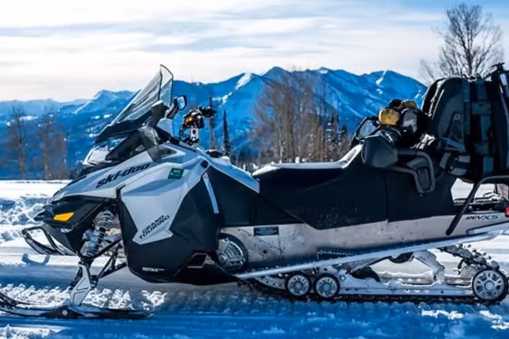 Ski-Doo snowmobile on snowy terrain with snow-capped mountains in background, Iceland