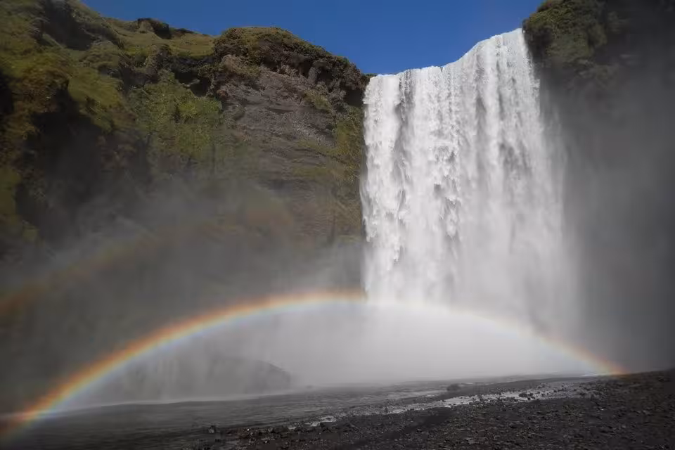 Skógafoss waterfall with double rainbow on Iceland's South Coast on a sunny day