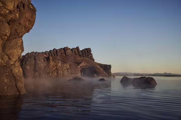 Misty geothermal waters beside volcanic rock formations at Sky Lagoon Iceland at dusk