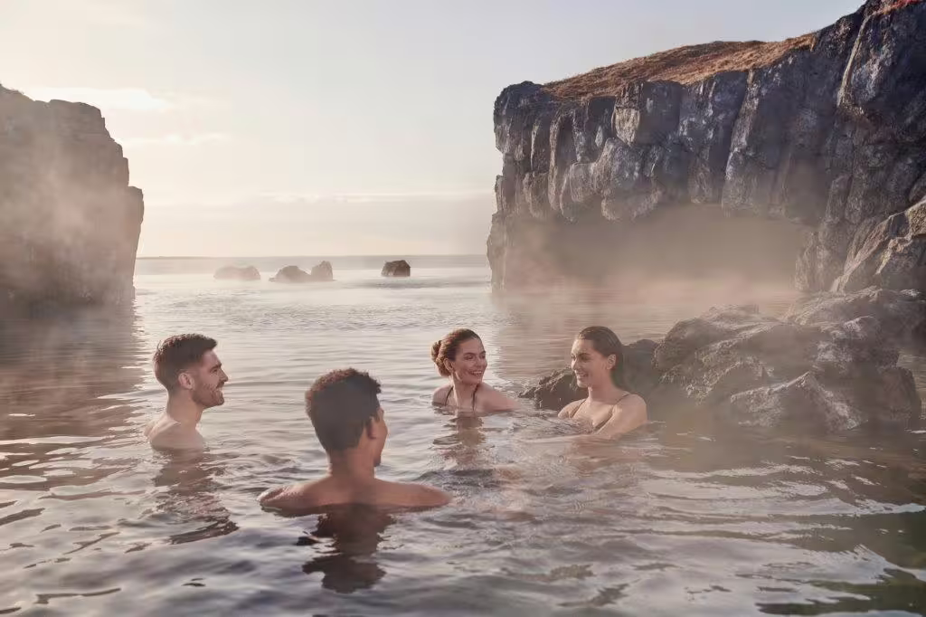 Visitors enjoy a relaxing soak in the geothermal waters of Sky Lagoon, surrounded by stunning Icelandic rock formations.