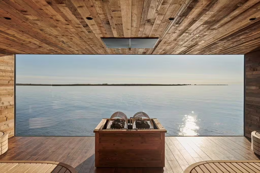 Relax in a serene wooden sauna overlooking the tranquil waters at Sky Lagoon, part of the Golden Circle and Friðheimar tour.