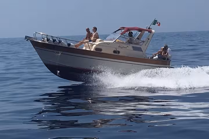 Small group on a speedboat navigating the serene waters near Capri on a tour from Sorrento.