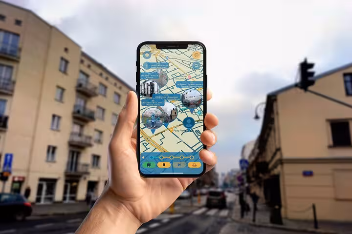 Hand holding a smartphone displaying an interactive map for the Praga District art walking tour in Warsaw streets.