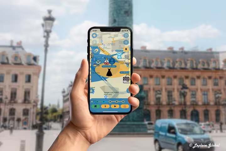 Hand holding smartphone displaying Paris fashion history walking tour app with interactive map near Place Vendôme Paris