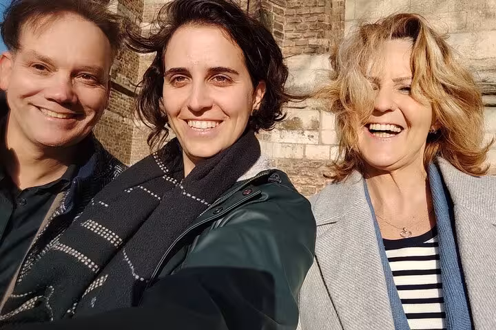 Three smiling visitors on a self-guided walking tour in Delft city center