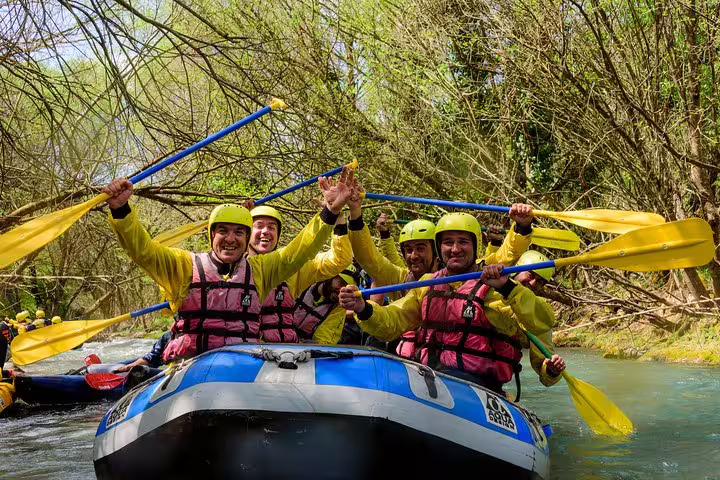 Smiling rafters paddling on Lousios River, Greece, during guided rafting tour on Alfeios and Lousios