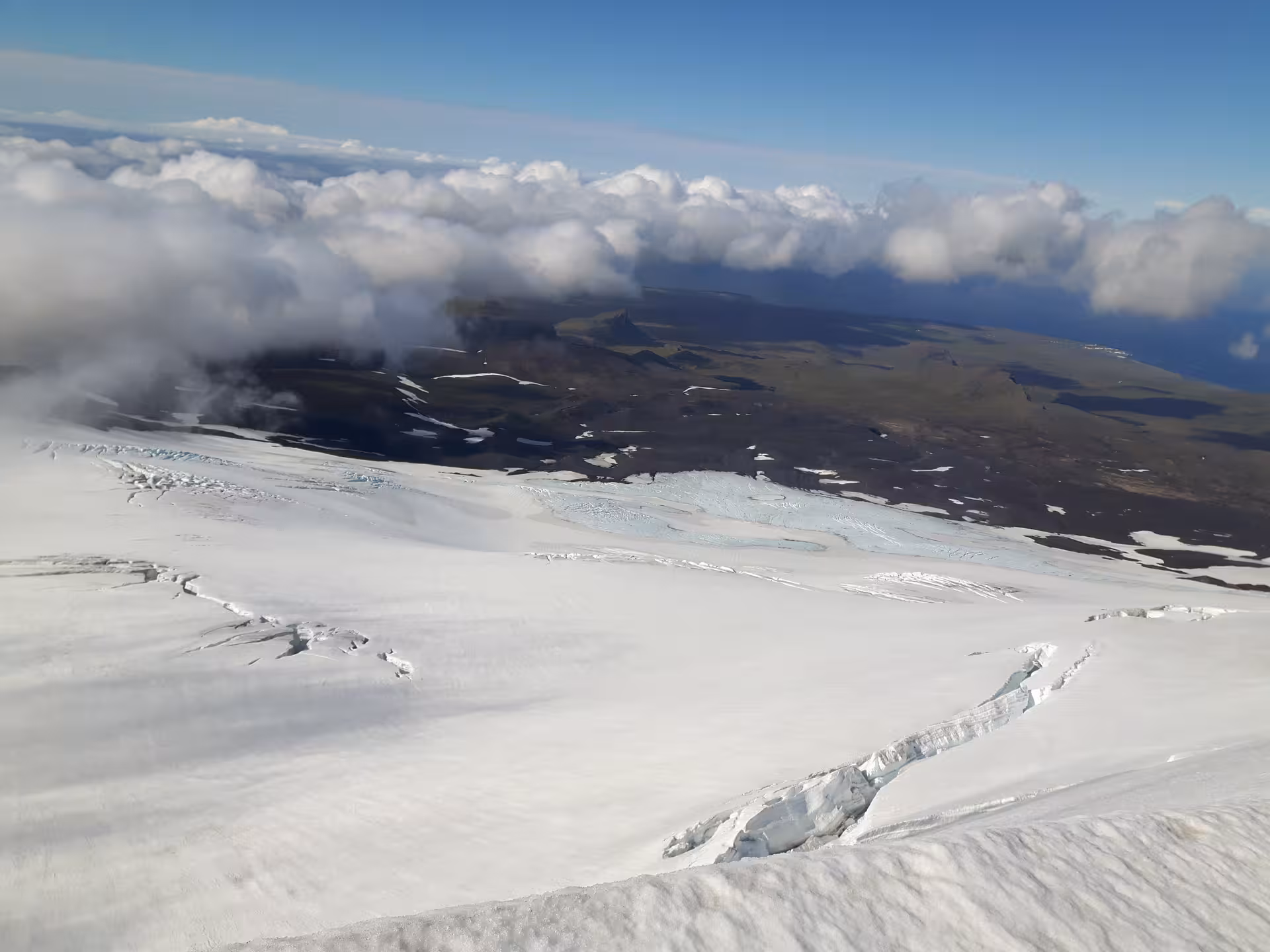 Aerial view of Snaefellsjokull glacier with crevasses, snow fields, and coastal landscape below