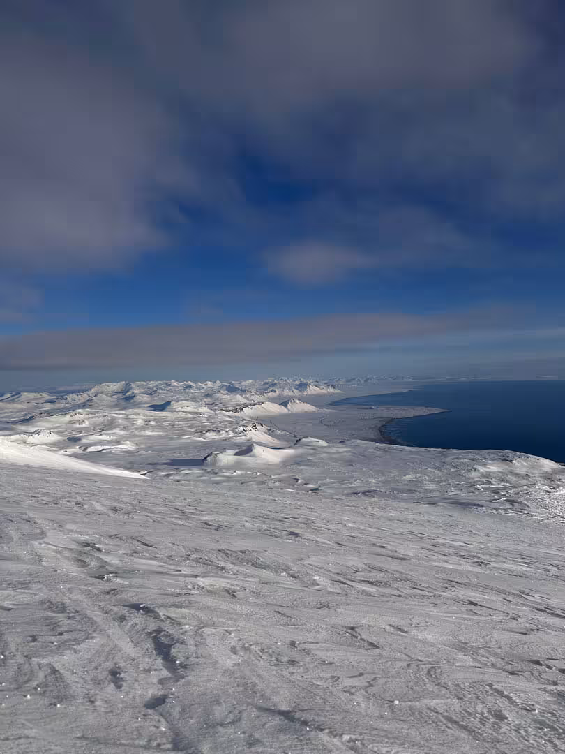 Aerial view of snow-covered Snaefellsjokull glacier summit with coastal waters and mountains in Iceland