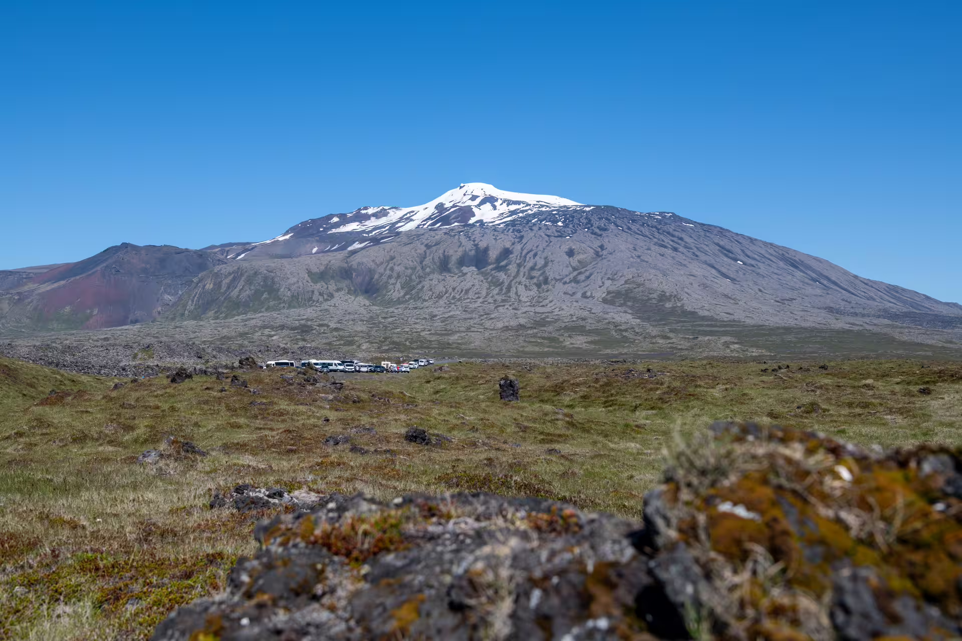 Snow-capped Snæfellsjökull volcano rising above green lava fields on the Snæfellsnes Peninsula, Iceland