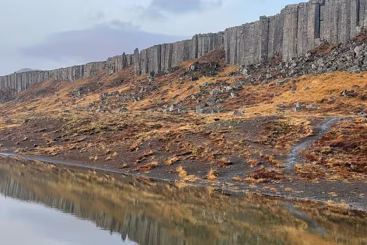 Basalt column cliffs reflected in calm water on Snaefellsnes Peninsula, Iceland