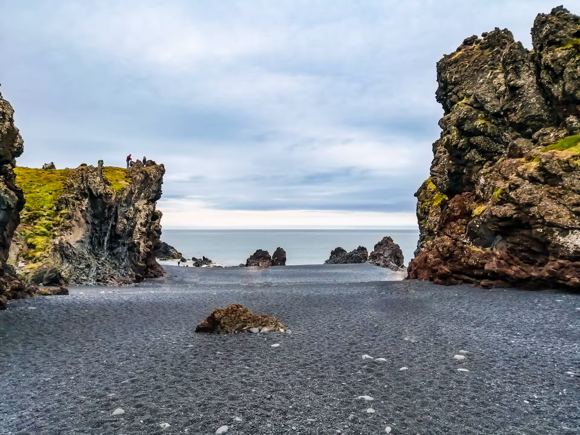 Black sand beach framed by dramatic volcanic cliffs on the Snaefellsnes Peninsula, Iceland