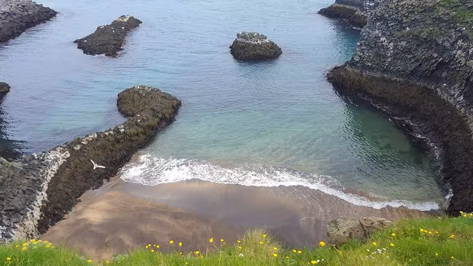 Secluded rocky cove with turquoise waters and sandy beach on Snaefellsnes Peninsula, Iceland