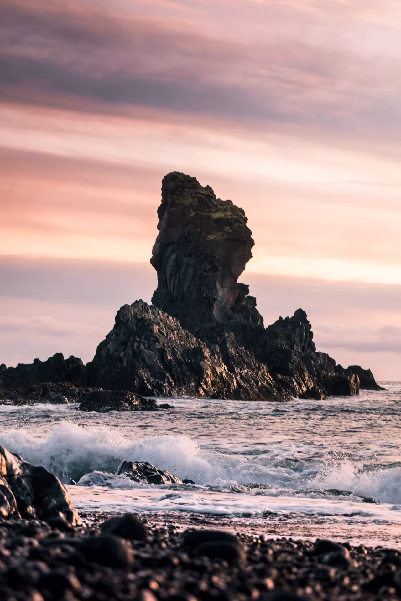 Dramatic sea stack rock formation on black pebble beach at sunset, Snaefellsnes Peninsula, Iceland
