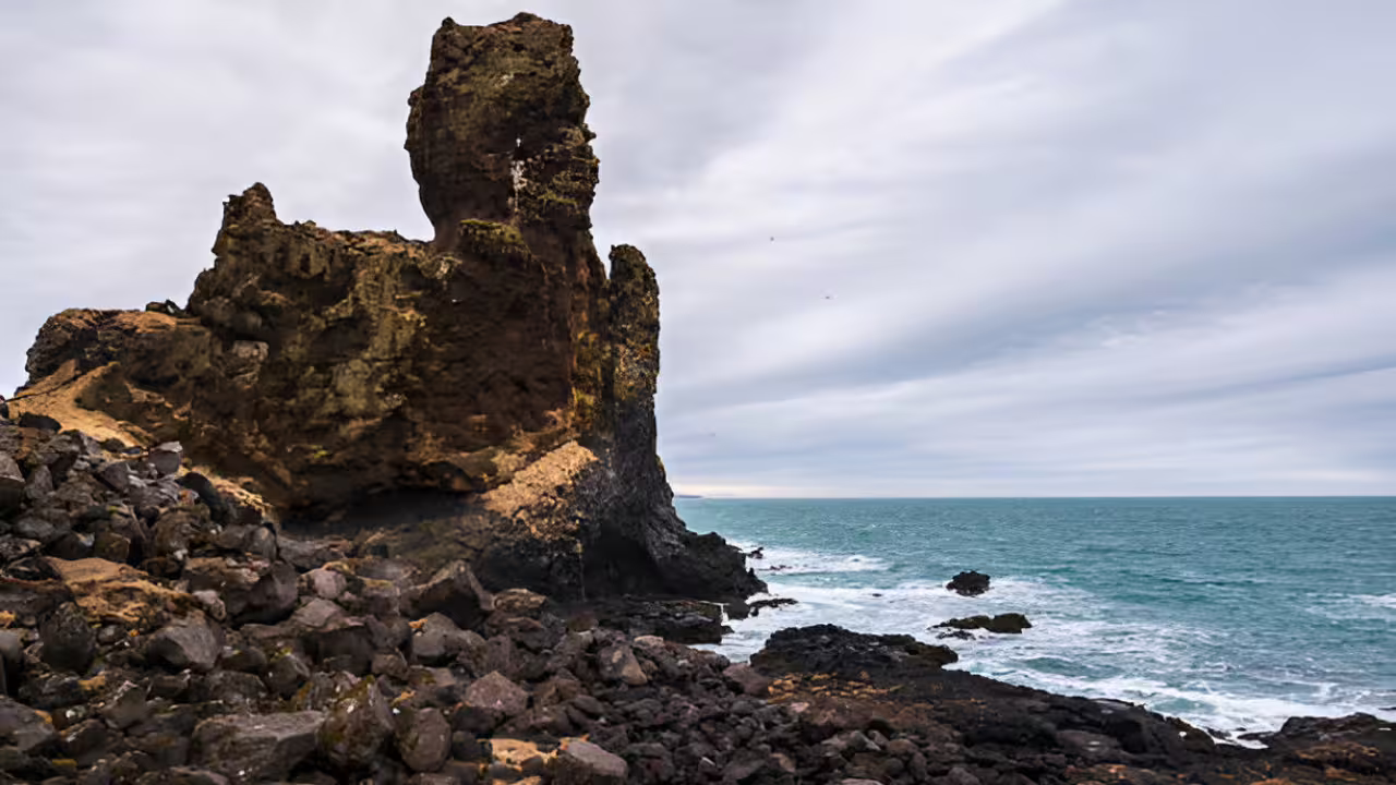 Dramatic volcanic rock formation on the rocky coastline of Snaefellsnes Peninsula, Iceland, with turquoise ocean waves