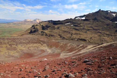 Red volcanic crater and lava fields on Snaefellsnes Peninsula with green valley below