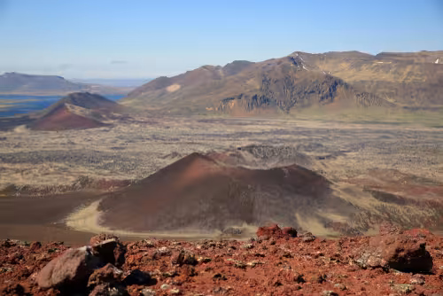 Red volcanic craters and lava fields on Snaefellsnes Peninsula Iceland under blue sky