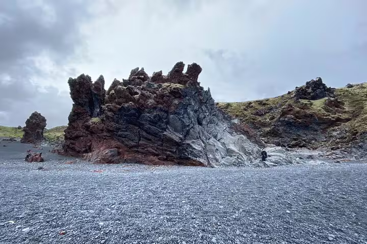 Jagged volcanic lava rock formation on black pebble beach at Snaefellsnes Peninsula, Iceland