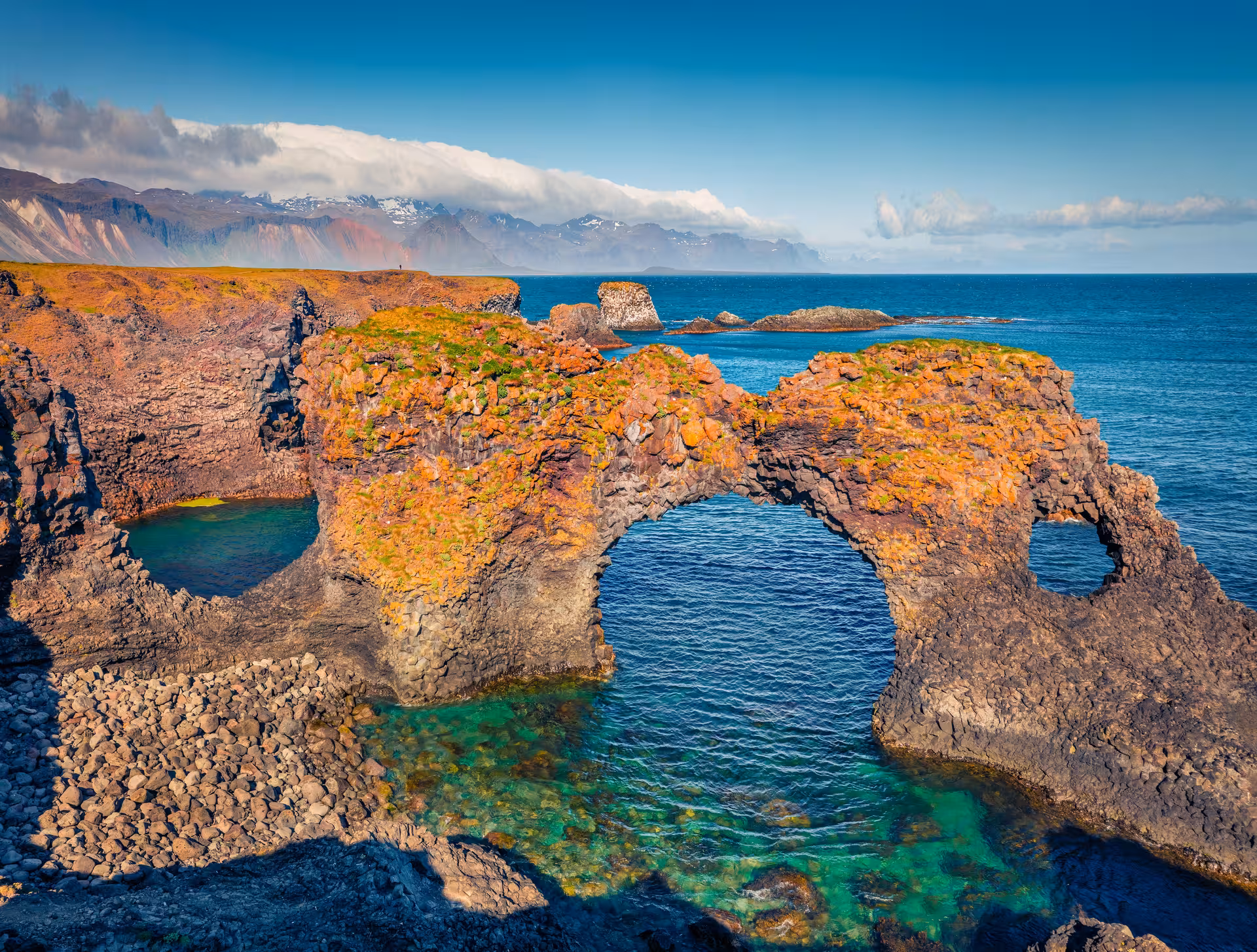 Natural rock arch on the Snaefellsnes Peninsula coastline with turquoise waters and volcanic cliffs