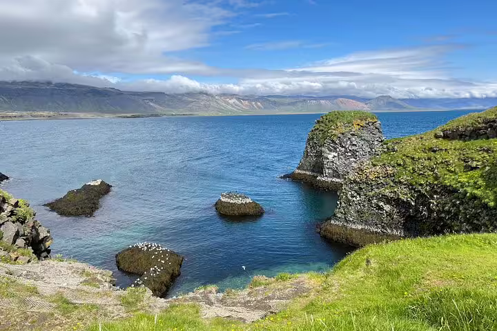 Rocky sea cliffs and blue waters of Snaefellsnes Peninsula on a sunny day